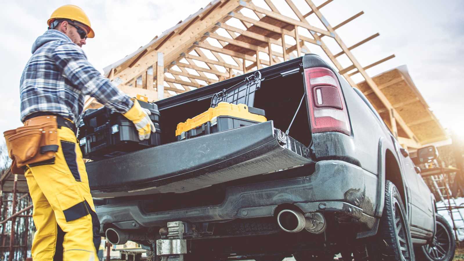 man pulling tools out of truck bed