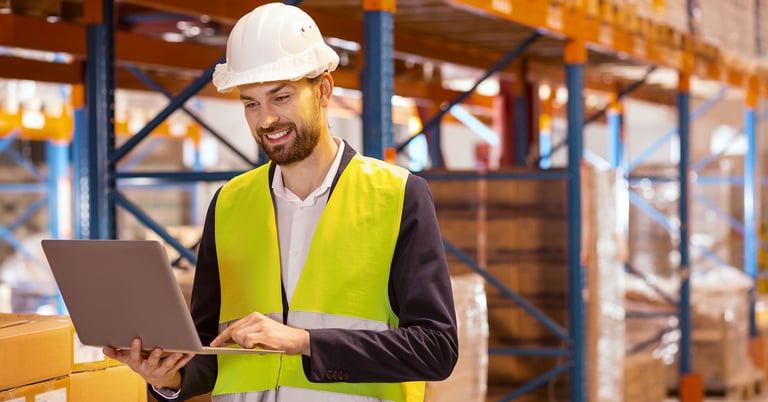 warehouse worker scrolling through a laptop