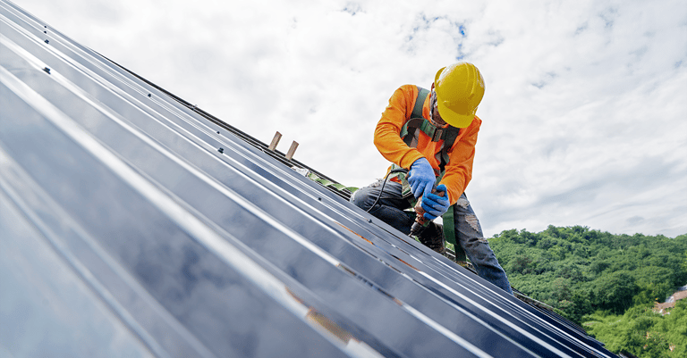 contractor working on solar roof panels