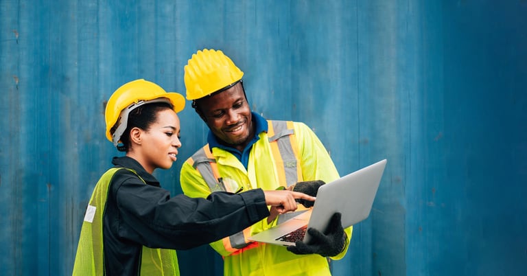 construction crew members viewing information on a laptop device
